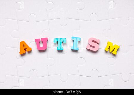 WORTAUTISMUS aus bunten Buchstaben auf weißen Puzzleteilen Stockfoto
