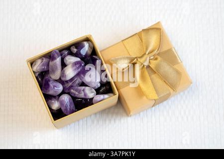 Set aus verschiedenen natürlichen Amethyst-Mineralsteinen und Edelsteinen auf violettem Hintergrund, teilweise fokussiert von oben Stockfoto