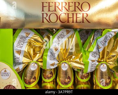 Italien - 25. März 2025: Ferrero Rocher Osterschokoladeneier mit Schaukelschokolade überraschend in Goldkarton zum Verkauf in italienischem Supermar Stockfoto