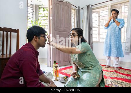 Indische Familie feiert Bhai dooj, ein hindufest, bei dem traditionelle Rituale zu Hause durchgeführt werden Stockfoto