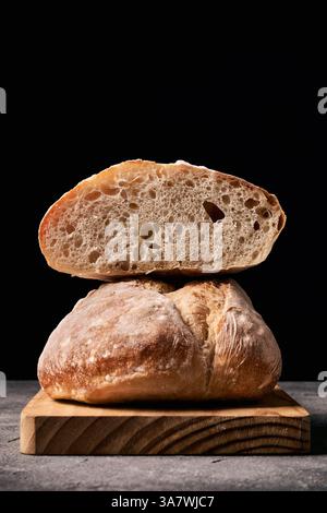 Frisch gebackenes Brot auf dem Schneidetisch Dunkler Hintergrund Stockfoto