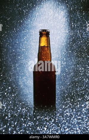 Glasflasche kaltes dunkles Bier, umgeben von funkelnden Lichtern Auf schwarzem Hintergrund Stockfoto