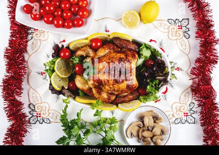 Blick von oben auf den festlichen Tisch serviert mit gebackenem Huhn mit Verschiedene Gemüse und in der Nähe von Tellern und Obst platziert Stockfoto