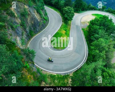 Blick aus der Vogelperspektive auf die kurvige Bergstraße und den grünen Wald im Sommer. Dolomiten, Italien. Blick von oben auf die gewundene Straße am Bergpass, Bäume im Frühling. Straße durch Stockfoto