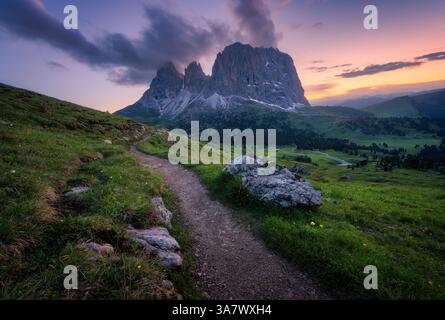 Berge bei schönem Sonnenuntergang im Sommer. Passo Sella, Dolomiten, Italien. Farbenfrohe Landschaft mit Berggipfeln, Felsen, Almwiesen, Wanderweg, grünem Grün Stockfoto