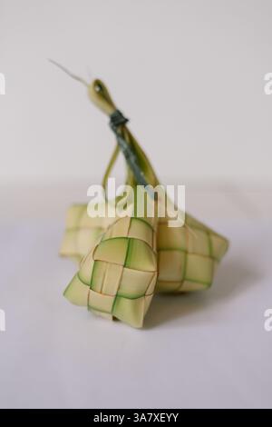 Nahaufnahme von Ketupat, einem Reisknödel in einem gewebten Palmblattbeutel, der oft während der Eid al-Fitr-Feierlichkeiten serviert wird. Es ist ein beliebtes Gericht in Stockfoto