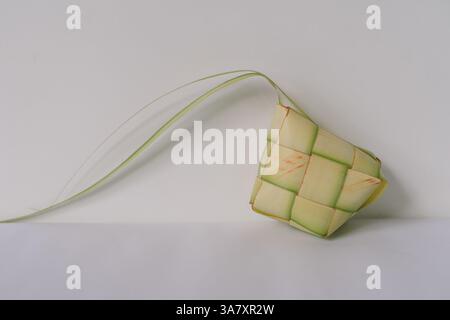 Nahaufnahme eines Ketupat-Hüllen, ein traditionelles indonesisches und malaiisches Gericht aus gewebten Palmblättern. Dieses komplizierte Gehäuse ist typischerweise gefüllt mit Witz Stockfoto