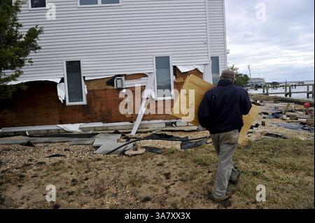 Oktober 31, 2012 - Toms River, New Jersey, USA S - Ein Bewohner des Toms River trägt Sperrholz, um Löcher in seinem Haus zu reparieren, die durch Sturmfluten verursacht wurden, zwei Tage nachdem Hurrikan Sandy im Süden von New Jersey über Land kam und weitverbreitete Überschwemmungen, Sachschäden und Stromausfälle verursachte. (Kreditbild: © Charles Mostoller/ZUMAPRESS.com) Stockfoto