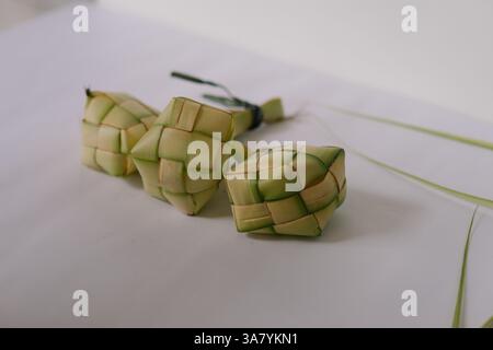 Nahaufnahme traditioneller Ketupat-Beutel, ein südostasiatisches Reisgericht aus Reis, der in gewebten Palmblättern verpackt ist. Es wird oft während der fes serviert Stockfoto