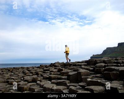 19. August 2011 - Causeway Coast, Nordirland, Vereinigtes Königreich - Ein Touristenspaziergang zwischen den Steinen am Giant's Causeway. Der Giant's Causeway ist ein Gebiet mit etwa 40.000 ineinander greifenden Basaltsäulen, das Ergebnis eines alten Vulkanausbruchs. (Bild: © Deirdre Hamill/ZUMAPRESS.com) Stockfoto