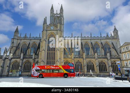Ein Doppeldeckerbus mit offenem Oberdeck Toot vor Bath Abbey, Bath, Somerset, England, Großbritannien Stockfoto