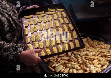 Kairo, Ägypten. März 2025. Eine ägyptische Frau macht traditionelle Kekse vor Eid al-Fitr in Kairo, Ägypten, am 27. März 2025. Quelle: Ahmed Gomaa/Xinhua/Alamy Live News Stockfoto