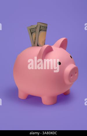 Nahaufnahme einer rosa Schweinebank mit 100-Dollar-Scheinen. Stockfoto