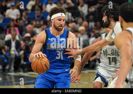 Orlando, Florida, USA, 27. März 2025, der Dallas Mavericks Wächter Klay Thompson #31 stürzt am Kia Center vorbei an Gary Harris #14. (Foto: Marty Jean-Louis/Alamy Live News Stockfoto