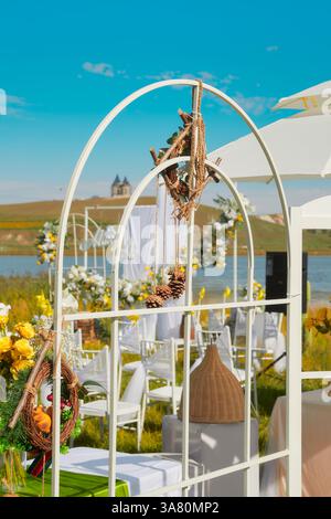 Hochzeitseinrichtung mit gelben Blumen und weißem Regenschirm Stockfoto