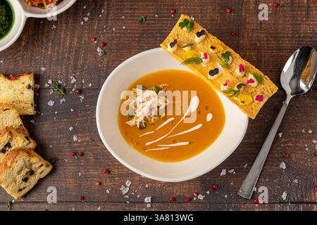 Blick von oben auf Kürbissuppe mit Croutons auf Holztisch Stockfoto