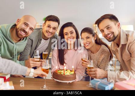 Happy Group Feiert Geburtstag Mit Kuchen Und Lächelt Die Kamera An Stockfoto