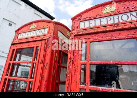 Truro England - 15.06.2024 - alte traditionelle englische rote Telefondosen mit abblätternder Farbe Stockfoto