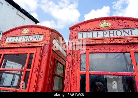 Truro England - 15.06.2024 - alte traditionelle englische rote Telefondosen mit abblätternder Farbe Stockfoto