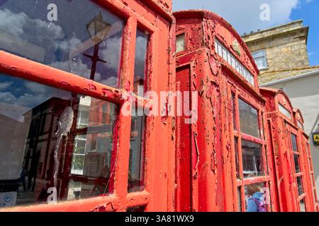 Truro England - 15.06.2024 - alte traditionelle englische rote Telefondosen mit abblätternder Farbe Stockfoto