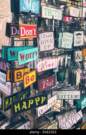 Dekorative Hängeschilder mit Text auf dem Brick Lane Market in London, England Stockfoto
