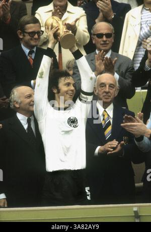 Vor 40 Jahren am 07.07.1974: Deutschland wird Weltmeister. Fußball-Weltmeisterschaft 1974: Finale Deutschland - Niederlande 2:1 am 7.7.1974 Trainer Franz Beckenbauer mit der WM-Trophäe. Links: Bundespräsident Walter Scheel rechts DFB-Präsident Goesmann. [Automatisierte Übersetzung] Stockfoto