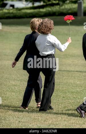 23. Oktober 2012 – Chelsea Clinton mit einer Seidenblume geht mit ihrer Mutter First Lady Hillary Rodham Clinton an Bord des Helikopters Marine One auf dem South Lawn des Weißen Hauses 19. August 1999 in Washington, DC. Die Clintons reisen zu Martha's Vineyard für einen Urlaub. (Bild: © Richard Ellis/ZUMAPRESS.com) Stockfoto