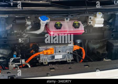 Elektrischer Van mit offener Motorhaube. Nahaufnahme des Wechselrichters und der Drähte. Stockfoto