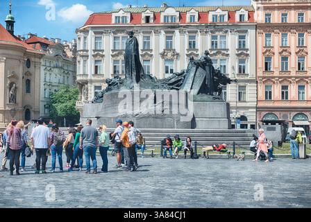 PRAG - 10. MAI 2024: Touristen stehen auf dem Altstadtplatz und bewundern das Jan-Hus-Denkmal in Prag, Tschechische Republik Stockfoto