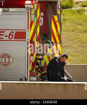 11. April 2013 - Irving, TX, USA - Ein Polizist wischt die Tränen ab, nachdem die letzten Passagiere aus einem Charterbus entfernt wurden, der am Donnerstag, den 11. April 2013, auf dem George Bush Highway in Irving, Texas, auf der Seite umkippte. Zwei Menschen starben bei dem Unfall, als der Bus auf den Betonmittelpunkt traf und umkippte. (Bild: © Tom Fox/MCT/ZUMAPRESS.com) Stockfoto