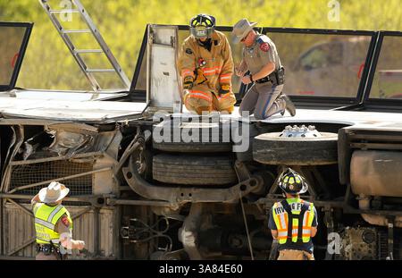 11. April 2013 - Irving, TX, USA - Texas DPS Offiziere und Feuerwehrleute inspizieren die Räder des Charterbusses, der am Donnerstag, den 11. April 2013, auf der Seite des George Bush Highway in Irving, Texas, umgekippt ist. Zwei Menschen starben bei dem Unfall, als der Bus auf den Betonmittelpunkt traf und umkippte. (Bild: © Tom Fox/MCT/ZUMAPRESS.com) Stockfoto