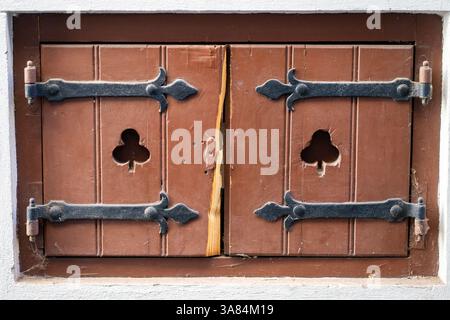 Blick auf alte alte Holzläden. Kleines Fenster mit Holzläden Stockfoto