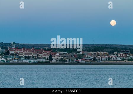 Vollmonduntergang am frühen Morgen über der Stadt Puerto Madryn, Argentinien Stockfoto
