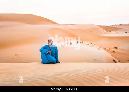 Mann steht auf einer Düne im Sharqiya Sands, früher bekannt als Wahiba Sands, Wüstenregion im Sultanat Oman Stockfoto