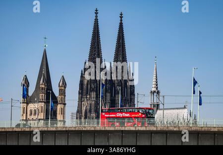 Köln, Deutschland. März 2025. Ein Stadtbus fährt bei sonnigem Wetter am Dom vorbei über die Deutz-Brücke. Quelle: Oliver Berg/dpa/Alamy Live News Stockfoto