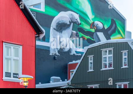 Blick auf das farbenfrohe Gebäude mit Eisbären- und Papageientaucher-Wandgemälde im Stadtzentrum an einem sonnigen Wintertag, Reykjavik, Island Stockfoto