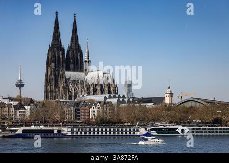 Köln, Deutschland. März 2025. Bei sonnigem Wetter fährt ein Boot über den Rhein am Dom vorbei. Quelle: Oliver Berg/dpa/Alamy Live News Stockfoto