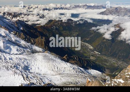 Atemberaubender Blick auf den Glacier des Bossons von Aiguille du Midi in den französischen Alpen mit Eisfeldern, die sich unter hohen Gipfeln erstrecken und klaren blauen Himmel Stockfoto