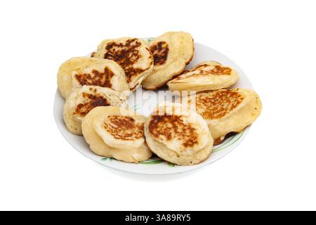 Hausgemachte gebratene Pfannkuchen auf einem weißen Teller, isoliert auf weißem Hintergrund. Perfekt für Frühstücksmenüs, Food Blogs oder kulinarische Designs. Stockfoto