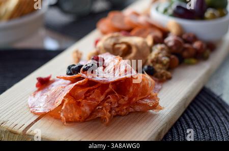 Nahaufnahme von dünn geschnittenem, gepökeltem Salamifleisch auf Wurstplatte mit selektivem Fokus Stockfoto