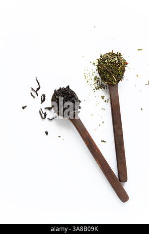 Schwarze und grüne Tees mit losen Blättern in Holzlöffeln isoliert auf weißem Hintergrund von oben Stockfoto