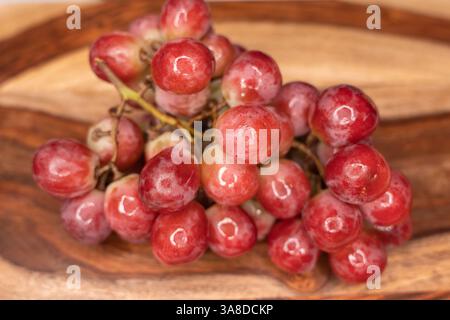 Frische rote Trauben auf einem hölzernen Schneidebrett. Stockfoto