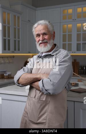 Porträt eines älteren Mannes mit Schürze in der Küche Stockfoto