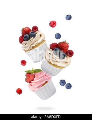 Leckere Cupcakes mit Creme und frischen Beeren in der Luft auf weißem Hintergrund Stockfoto