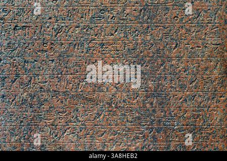 Abu Dhabi, Vereinigte Arabische Emirate - 17. Januar 2024, Nahaufnahme der antiken ägyptischen Hieroglyphen, die auf einer Granitplatte in der Ausstellung des Louvre Abu Dhab gemeißelt wurden Stockfoto