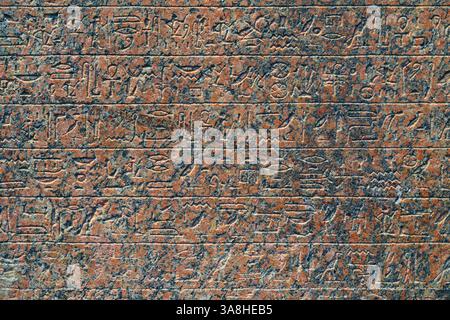 Abu Dhabi, Vereinigte Arabische Emirate - 17. Januar 2024, Nahaufnahme der antiken ägyptischen Hieroglyphen, die auf einer Granitplatte in der Ausstellung des Louvre Abu Dhab gemeißelt wurden Stockfoto