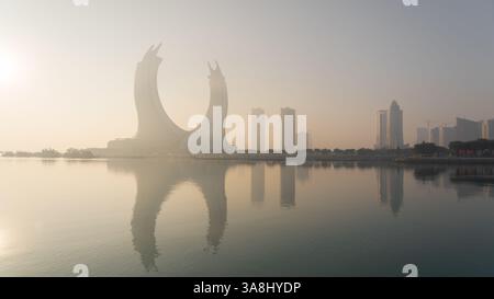 Doha, Katar [24. Februar 2025]: Ein nebeliger Morgen in Doha mit Wolkenkratzern, die teilweise im Nebel verborgen sind und eine geheimnisvolle und ruhige Stadtlandschaft schaffen. Stockfoto