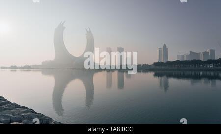 Doha, Katar [24. Februar 2025]: Ein nebeliger Morgen in Doha mit Wolkenkratzern, die teilweise im Nebel verborgen sind und eine geheimnisvolle und ruhige Stadtlandschaft schaffen. Stockfoto