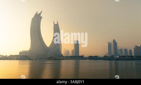 Doha, Katar [24. Februar 2025]: Ein nebeliger Morgen in Doha mit Wolkenkratzern, die teilweise im Nebel verborgen sind und eine geheimnisvolle und ruhige Stadtlandschaft schaffen. Stockfoto
