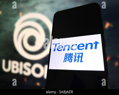 SUQIAN, CHINA - 29. MÄRZ 2025 - Eine Illustration zeigt das Tencent-LOGO auf einem Mobiltelefon mit dem UBISOFT-Logo auf dem Boden in Suqi Stockfoto
